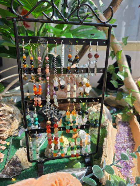 Boucle d oreilles Présentoir en fer avec des boucles d'oreilles colorées et des accessoires en pierres.