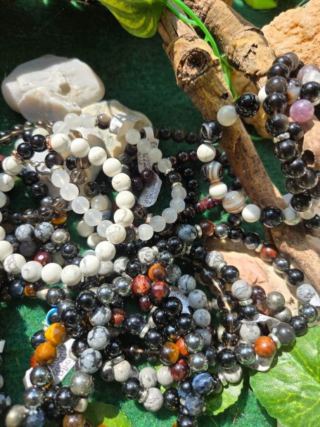 Bracelets personnalisés Un assortiment de bracelets en perles colorées sur un fond vert.